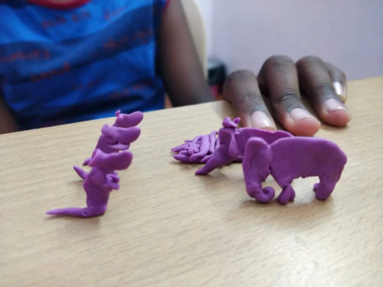 Small purple clay animals, including an elephant and a kangaroo, on a therapy table